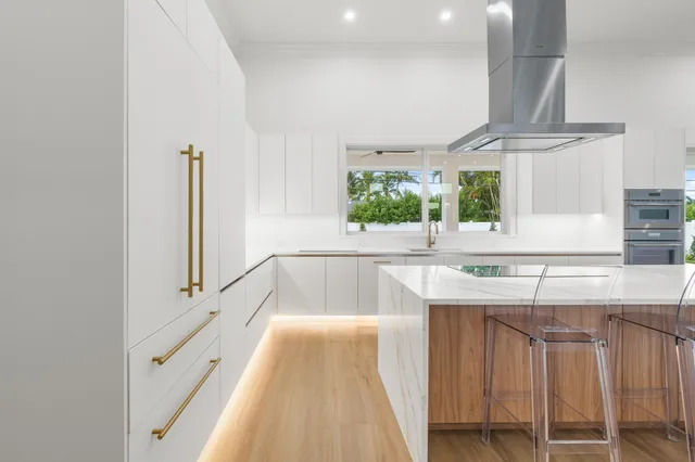 a view of a kitchen with kitchen island granite countertop a sink and a stove top oven