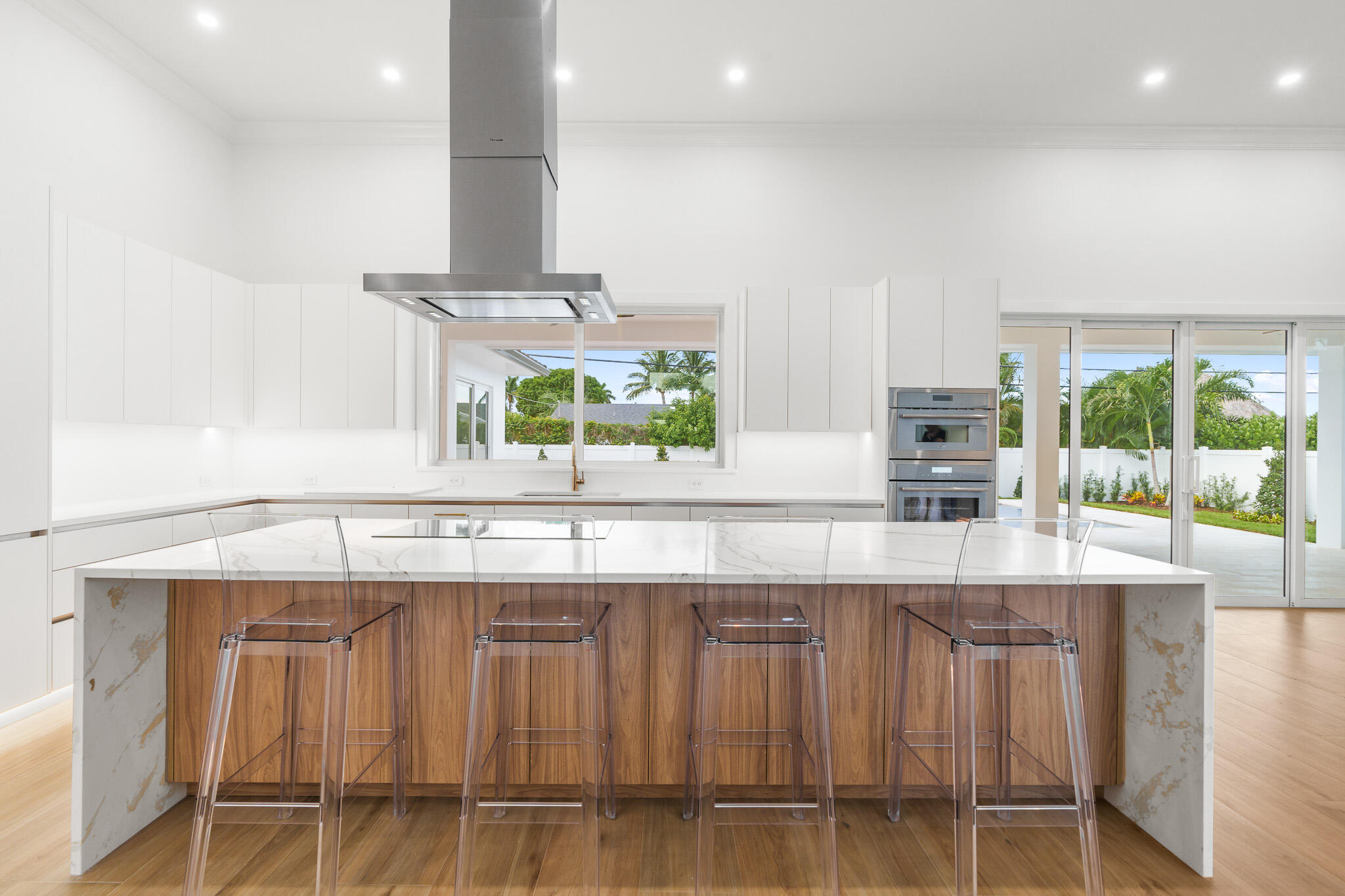 803 Sunset Road Boynton Beach, FL 33435 - Photo 12 of 57 a kitchen with stainless steel appliances kitchen island granite countertop a table chairs in it and wooden floors