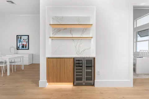 a view of an empty room with wooden floor and a cabinet