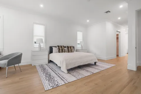 a spacious bedroom with a large bed and a wooden floor