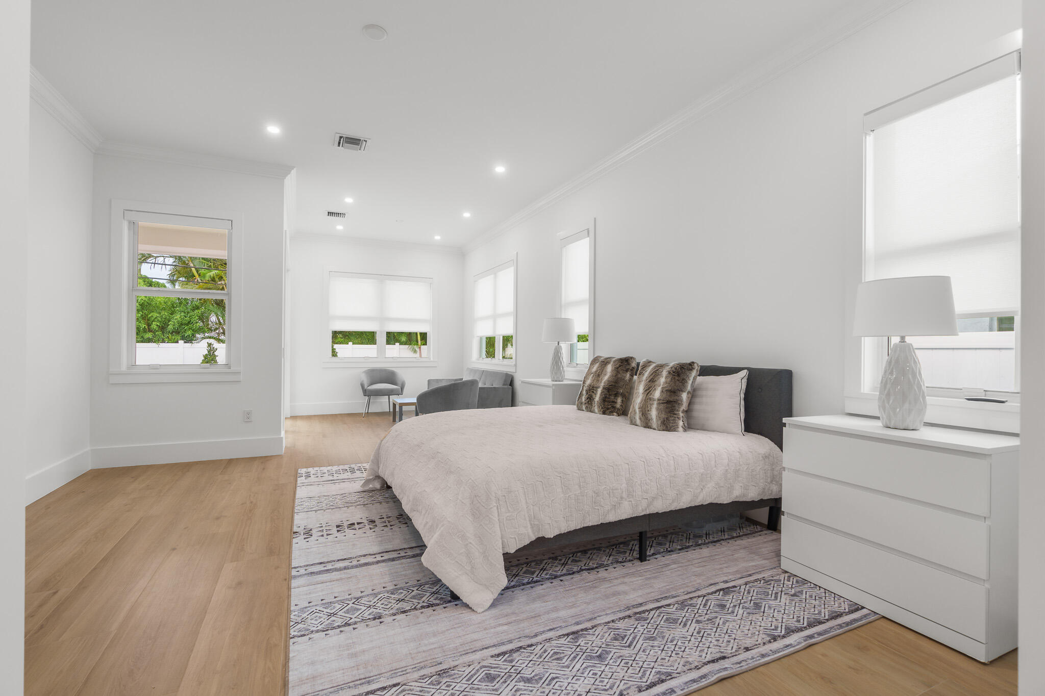 803 Sunset Road Boynton Beach, FL 33435 - Photo 24 of 57 a spacious bedroom with a large bed and a wooden floor