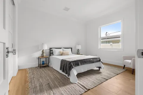 a bedroom with a bed and wooden floor