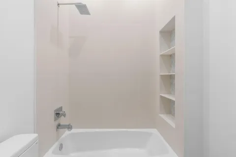 a bathroom with a granite countertop toilet sink and mirror