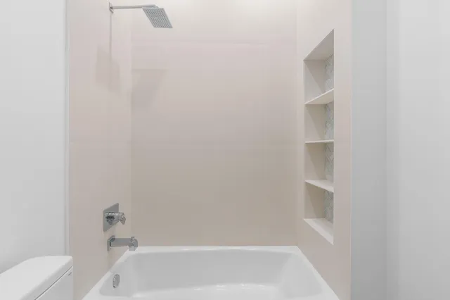 a bathroom with a granite countertop toilet sink and mirror