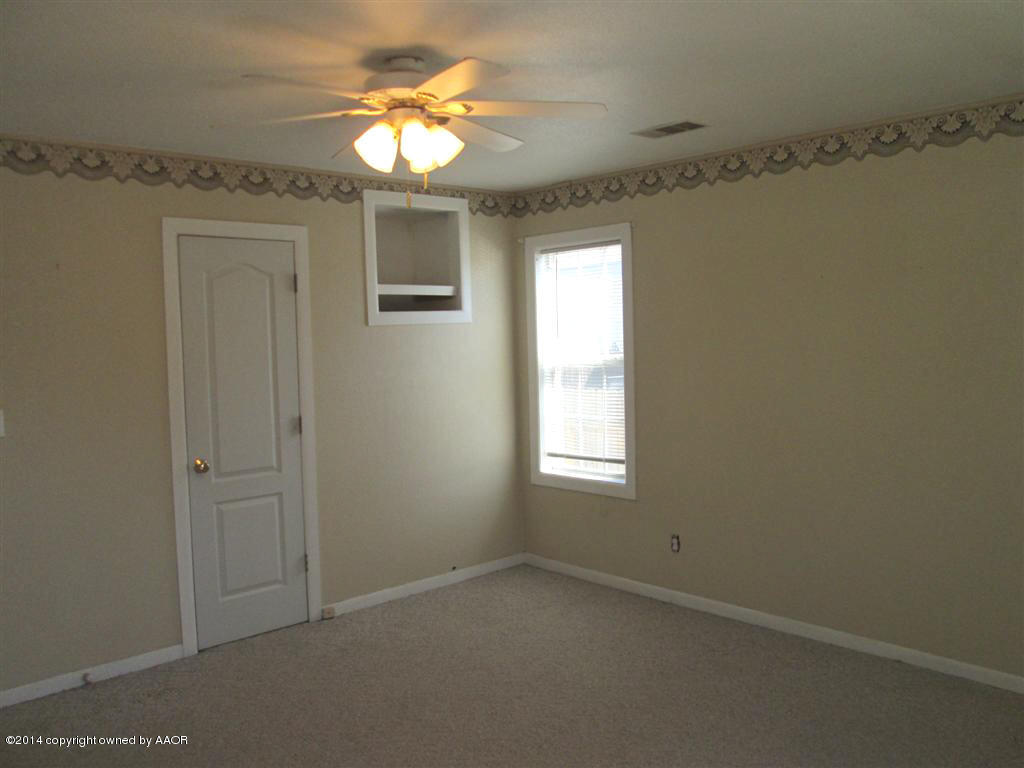 4017 Bowie Street Amarillo, TX 79110 - Photo 22 of 34 en empty room with windows and chandelier fan