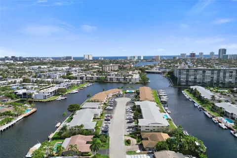 an aerial view of a city with lots of residential buildings ocean and mountain view in back