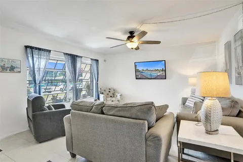 a living room with furniture a lamp and a large window