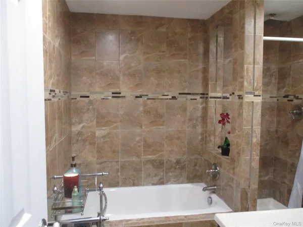 a bath tub sitting next to a white sink and a shower