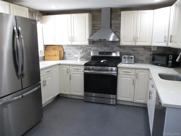 a kitchen with white cabinets and stainless steel appliances