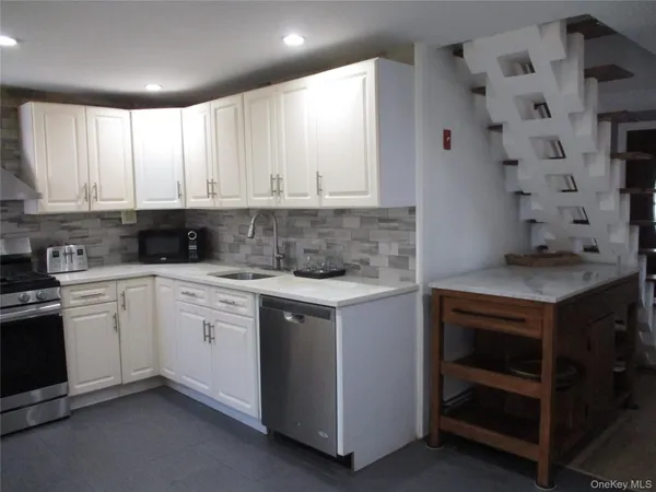 a kitchen with granite countertop white cabinets and white appliances