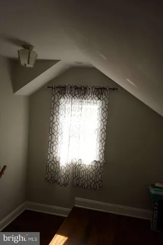 a bed sitting in a bedroom next to a window with dresser