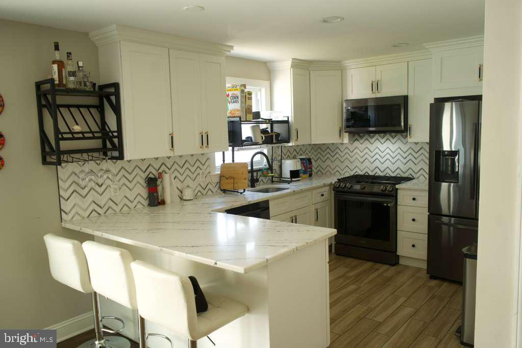 133 Heulings Avenue Riverside, NJ 08075 - Photo 9 of 31 a kitchen with stainless steel appliances granite countertop a sink and a stove