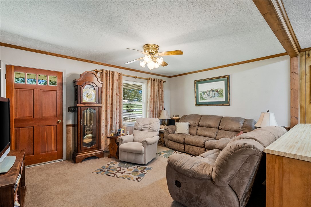 312 Edwards Drive Anderson, SC 29626 - Photo 5 of 44 A welcoming living room featuring a rich wood entry door and a decorative ceiling fan with light fixture.