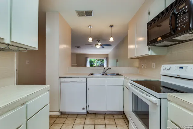 a kitchen with a sink cabinets and appliances