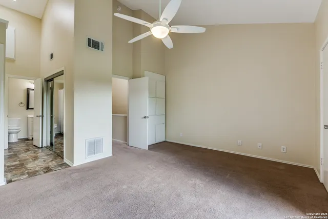 an empty room with a ceiling fan and a bathroom