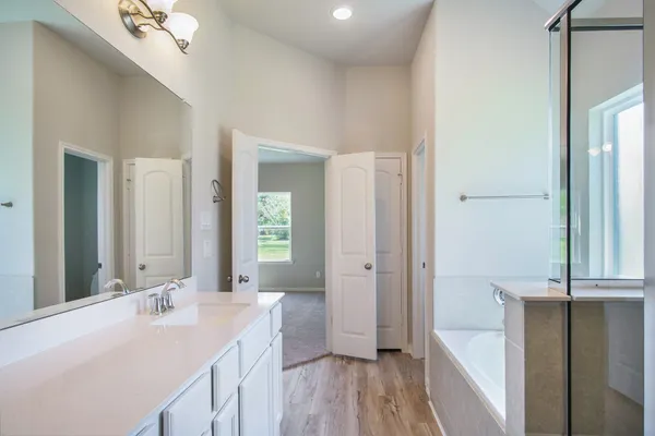 a spacious bathroom with a double vanity sink a mirror and a shower