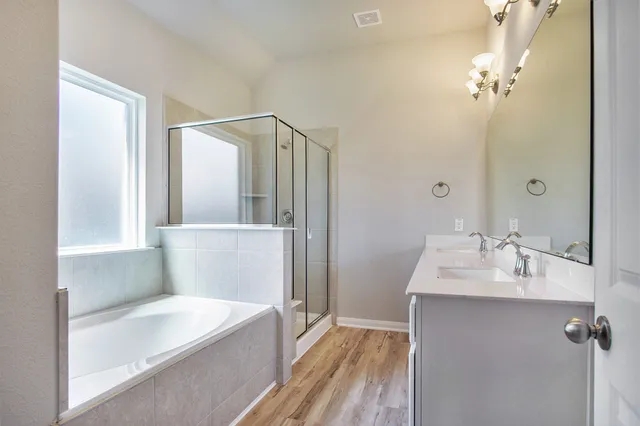 a bathroom with a tub sink and mirror
