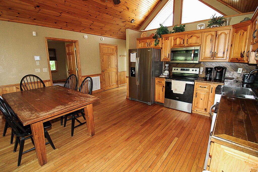 443 Loop Road Gatlinburg, TN 37738 - Photo 7 of 40 a kitchen with stainless steel appliances a kitchen island hardwood floor sink stove dining table and chairs