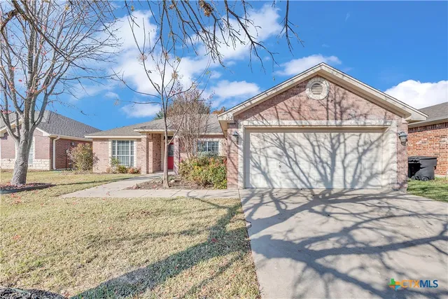 a view of a house with a yard and wooden fence