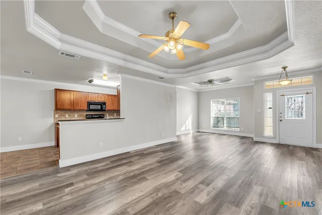 a view of a livingroom with wooden floor and a ceiling fan
