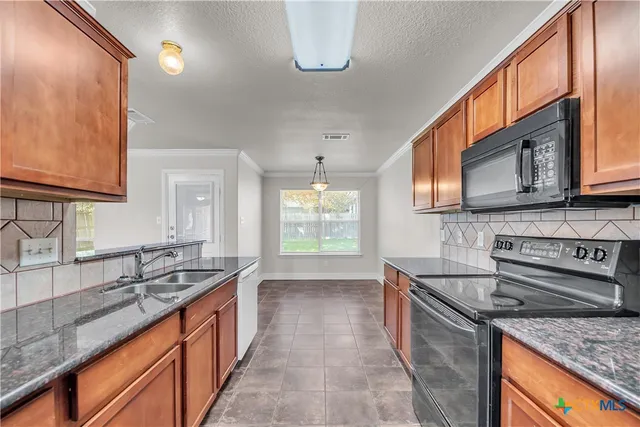 a kitchen with stainless steel appliances granite countertop a sink stove and cabinets