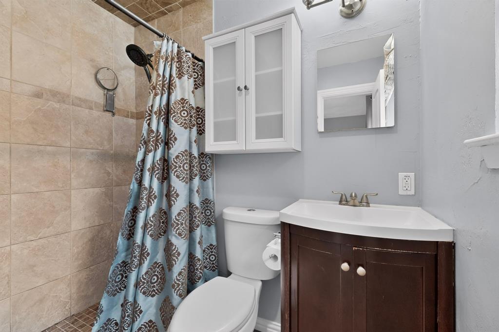 2309 Fyke Road Carrollton, TX 75006 - Photo 21 of 40 Shower with tiled surround and dark bronze fixtures