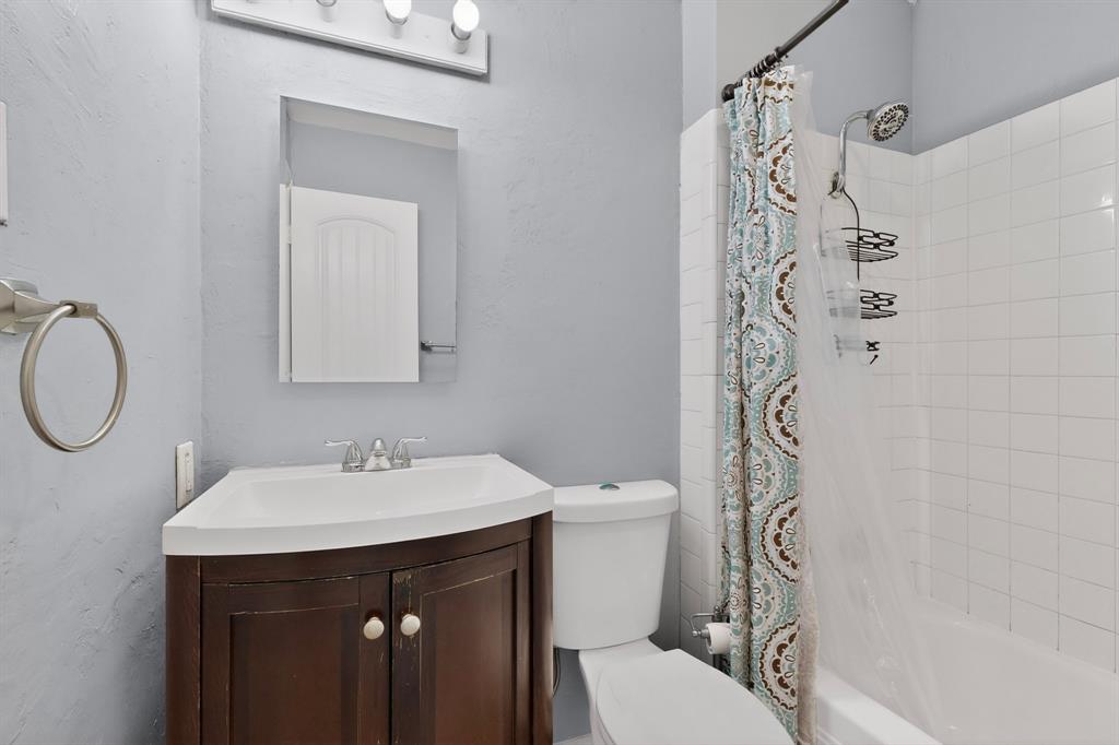 2309 Fyke Road Carrollton, TX 75006 - Photo 26 of 40 Bathroom featuring a corner vanity with a white countertop and dark wood-finish cabinetry