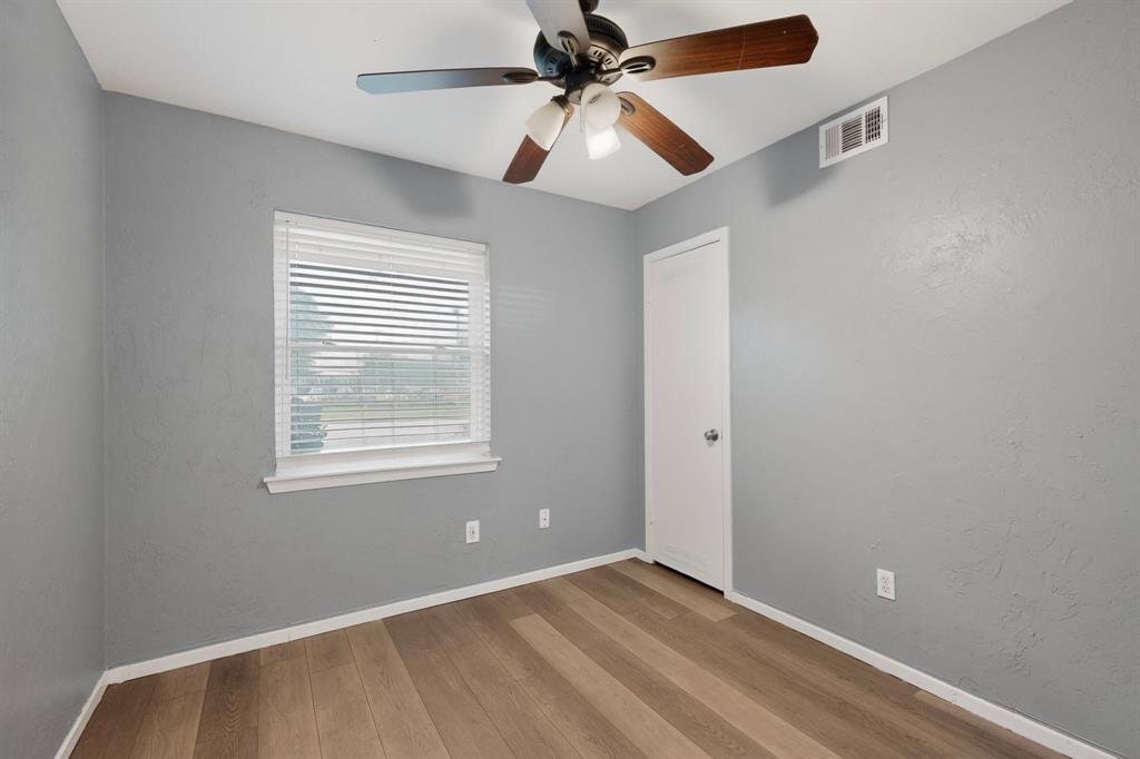 2309 Fyke Road Carrollton, TX 75006 - Photo 29 of 40 Room featuring wood-finish flooring, a ceiling fan with light fixture, and a window with blinds