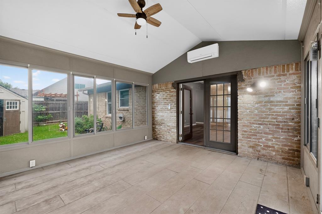 2309 Fyke Road Carrollton, TX 75006 - Photo 35 of 40 Sunroom featuring a wood-finish ceiling fan, split air conditioning unit, light-colored tile flooring, exposed brick wall, and French patio doors