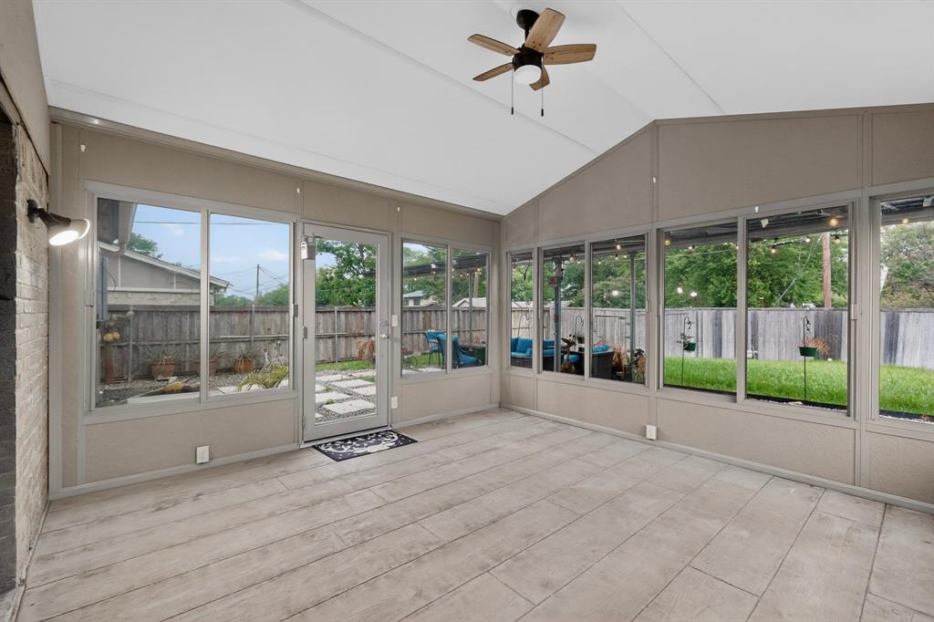 2309 Fyke Road Carrollton, TX 75006 - Photo 36 of 40 Spacious sunroom featuring extensive window panels, vaulted ceilings, and wood-finish flooring