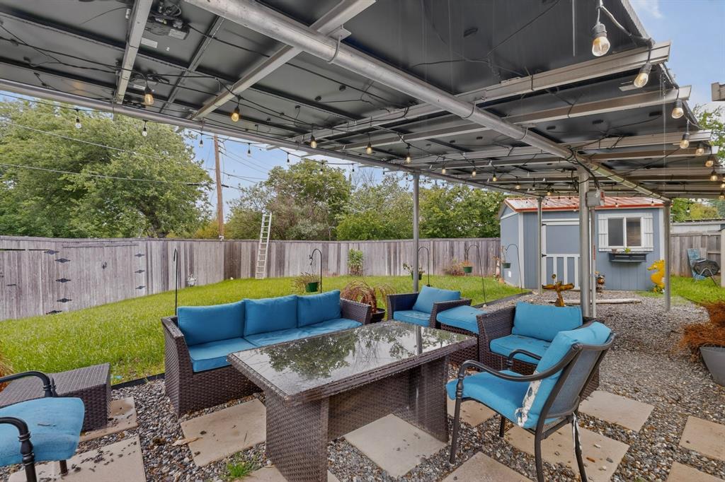 2309 Fyke Road Carrollton, TX 75006 - Photo 37 of 40 Outdoor patio featuring a metal pergola with string lighting, a gravel and paver patio surface, and a fenced backyard