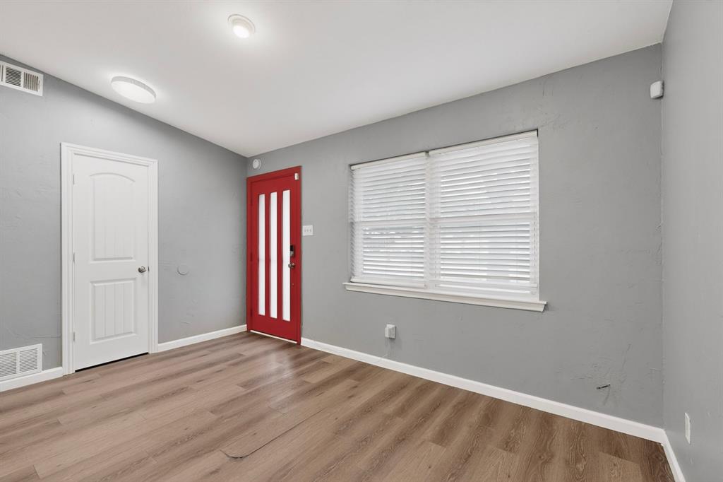 2309 Fyke Road Carrollton, TX 75006 - Photo 6 of 40 Entry area featuring wood-finish flooring, a vibrant red door with vertical lites, a white interior door, a window with blinds, and recessed ceiling lighting