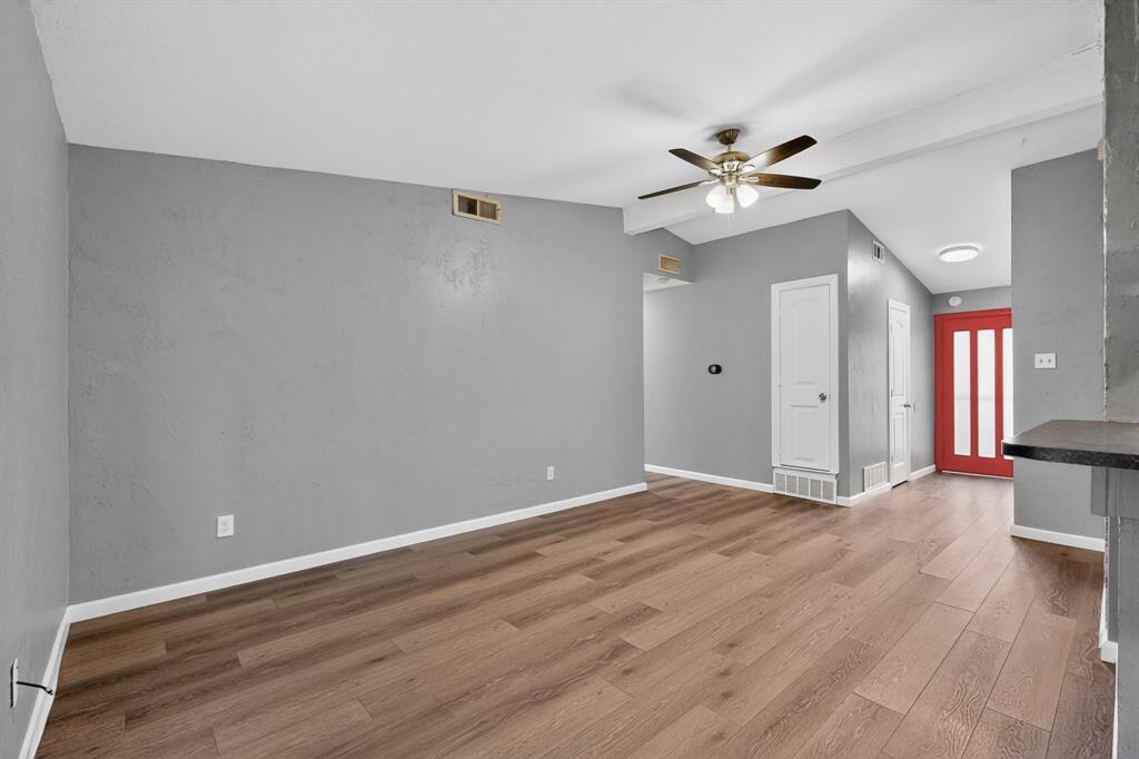 2309 Fyke Road Carrollton, TX 75006 - Photo 9 of 40 Spacious interior featuring wood-finish flooring, vaulted ceilings, and a bronze-finish ceiling fan