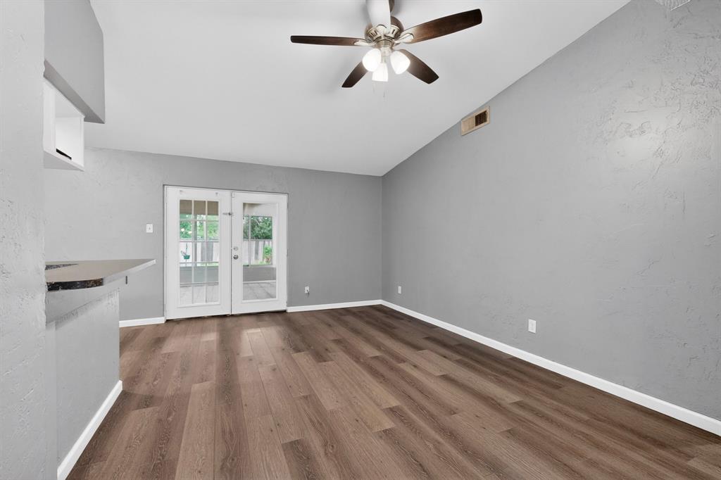 2309 Fyke Road Carrollton, TX 75006 - Photo 10 of 40 Spacious room featuring wood-finish flooring, vaulted ceilings, and a ceiling fan with light fixture