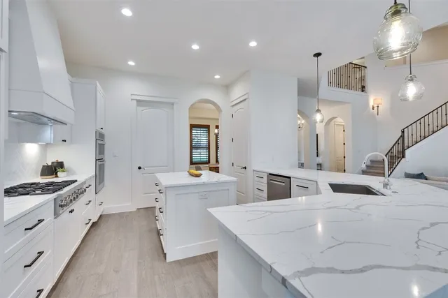 a kitchen with granite countertop stainless steel appliances and white cabinets