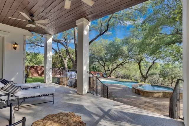 an empty room that has a window and a ceiling fan