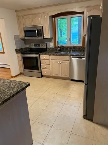 a kitchen with stainless steel appliances granite countertop a stove a sink and a refrigerator