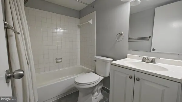 an empty room with wooden floor closet fan and windows