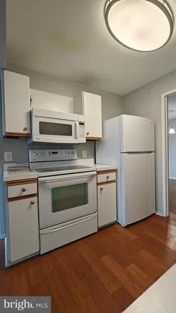 a kitchen with stainless steel appliances a refrigerator and wooden floor
