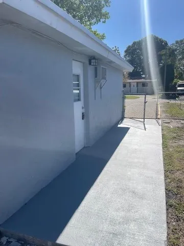 a view of a patio with table and chairs with wooden floor and fence