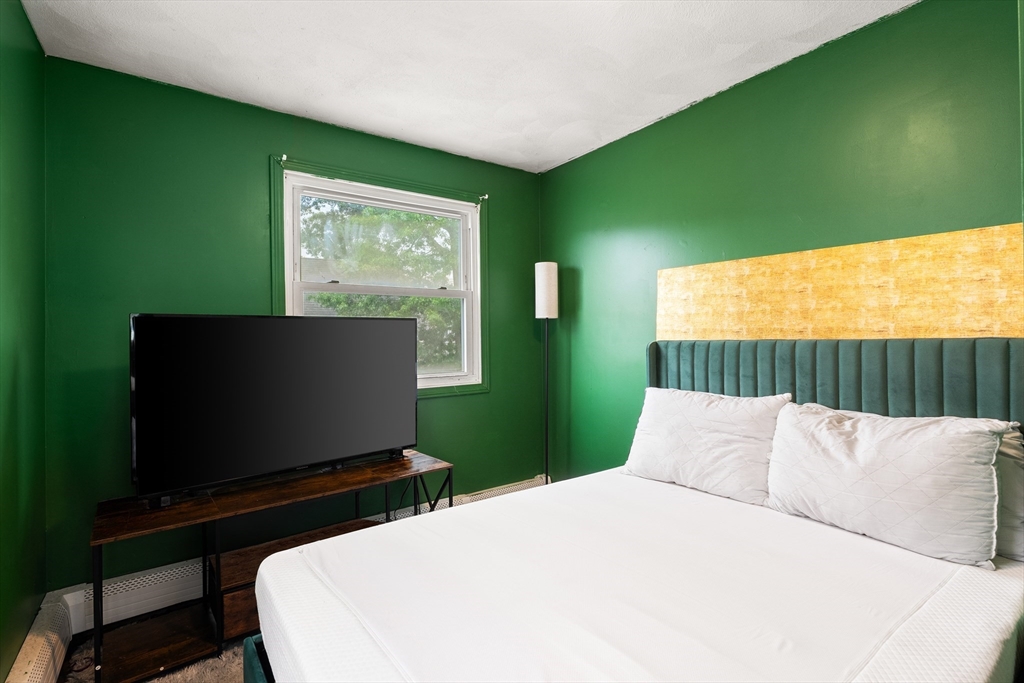 23 Logan Street Lynn, MA 01902 - Photo 15 of 27 a bedroom with a bed and a flat screen tv
