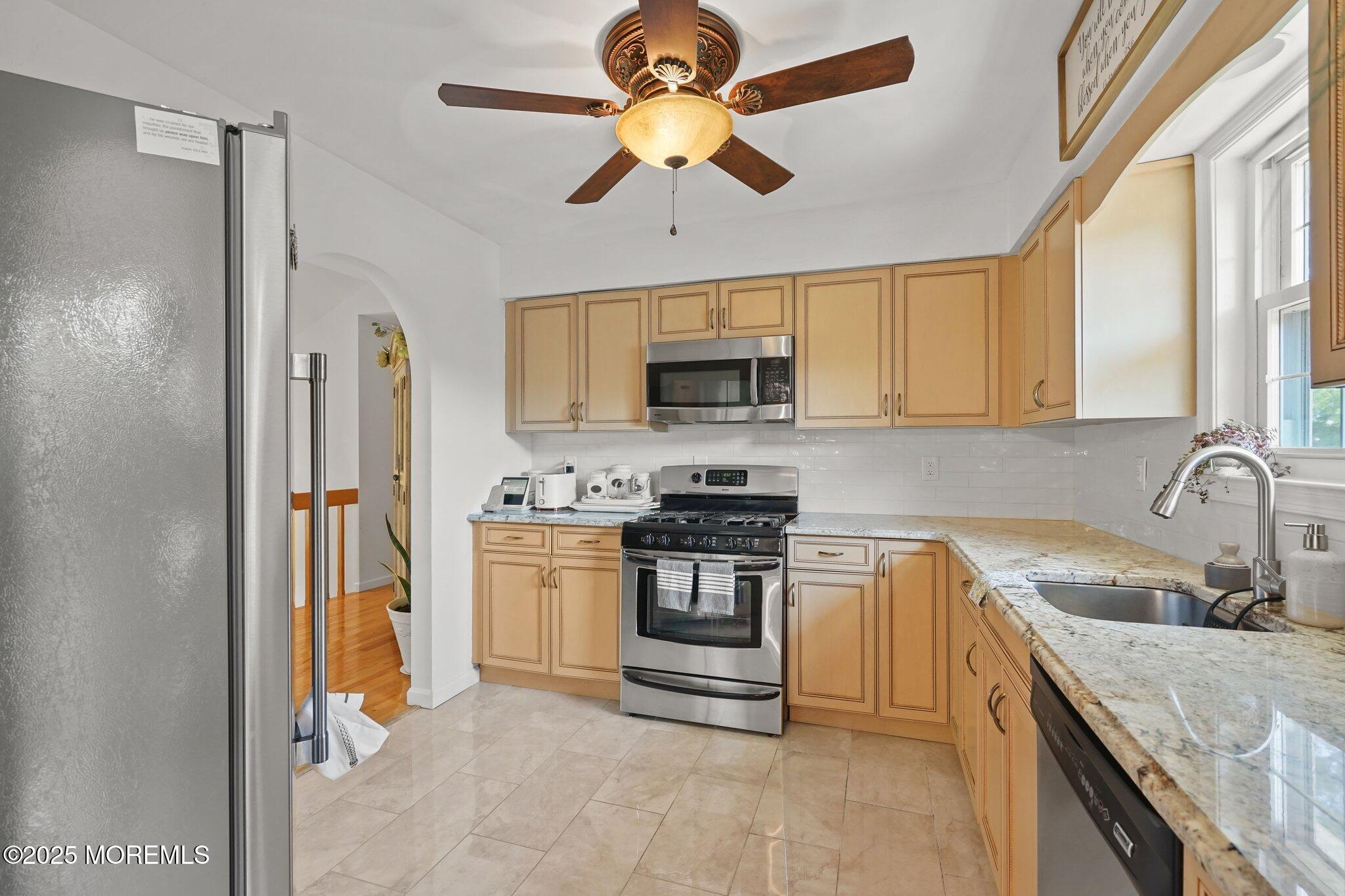 38 Sweet Gum Road Howell, NJ 07731 - Photo 22 of 23 a kitchen with stainless steel appliances granite countertop a sink a stove a refrigerator with a dining table and chairs
