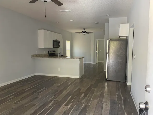a view of a kitchen with a sink and a refrigerator