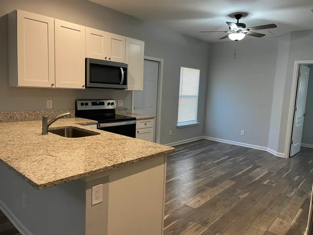 a kitchen with a sink a microwave and cabinets