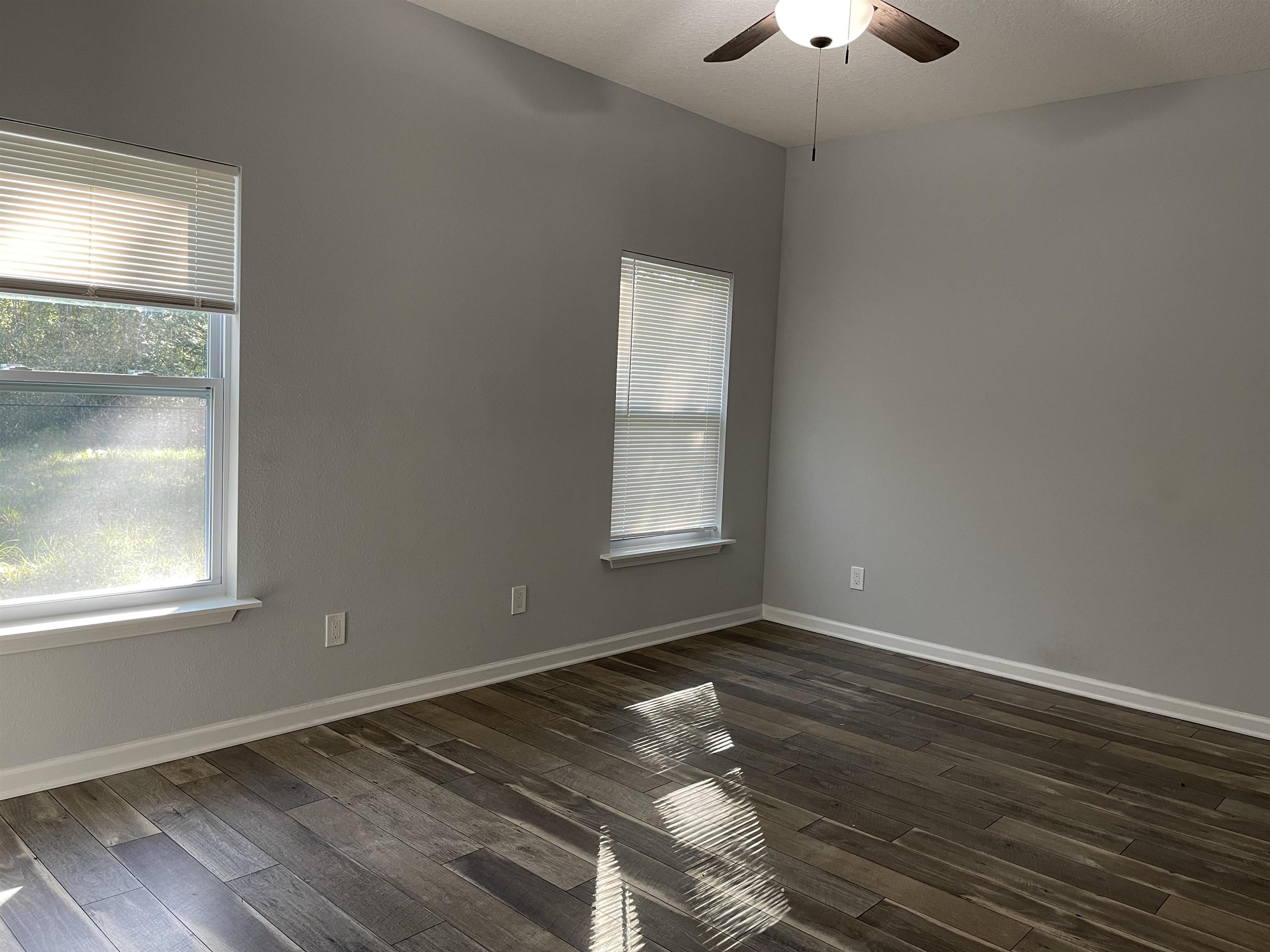 867 Helen Street St. Augustine, FL 32084 - Photo 5 of 11 an empty room with wooden floor cabinet and windows