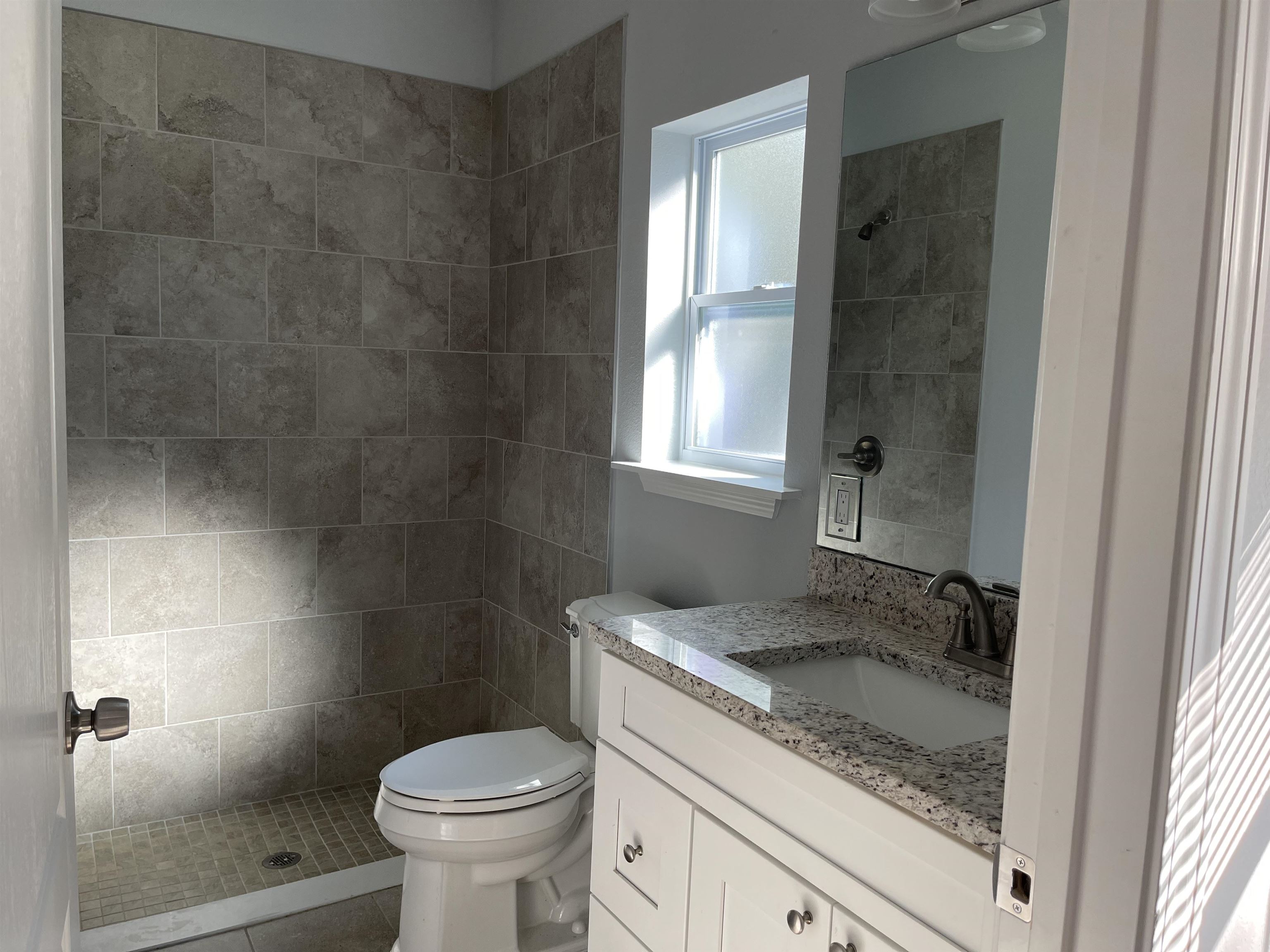 867 Helen Street St. Augustine, FL 32084 - Photo 6 of 11 a bathroom with a granite countertop sink a toilet and shower