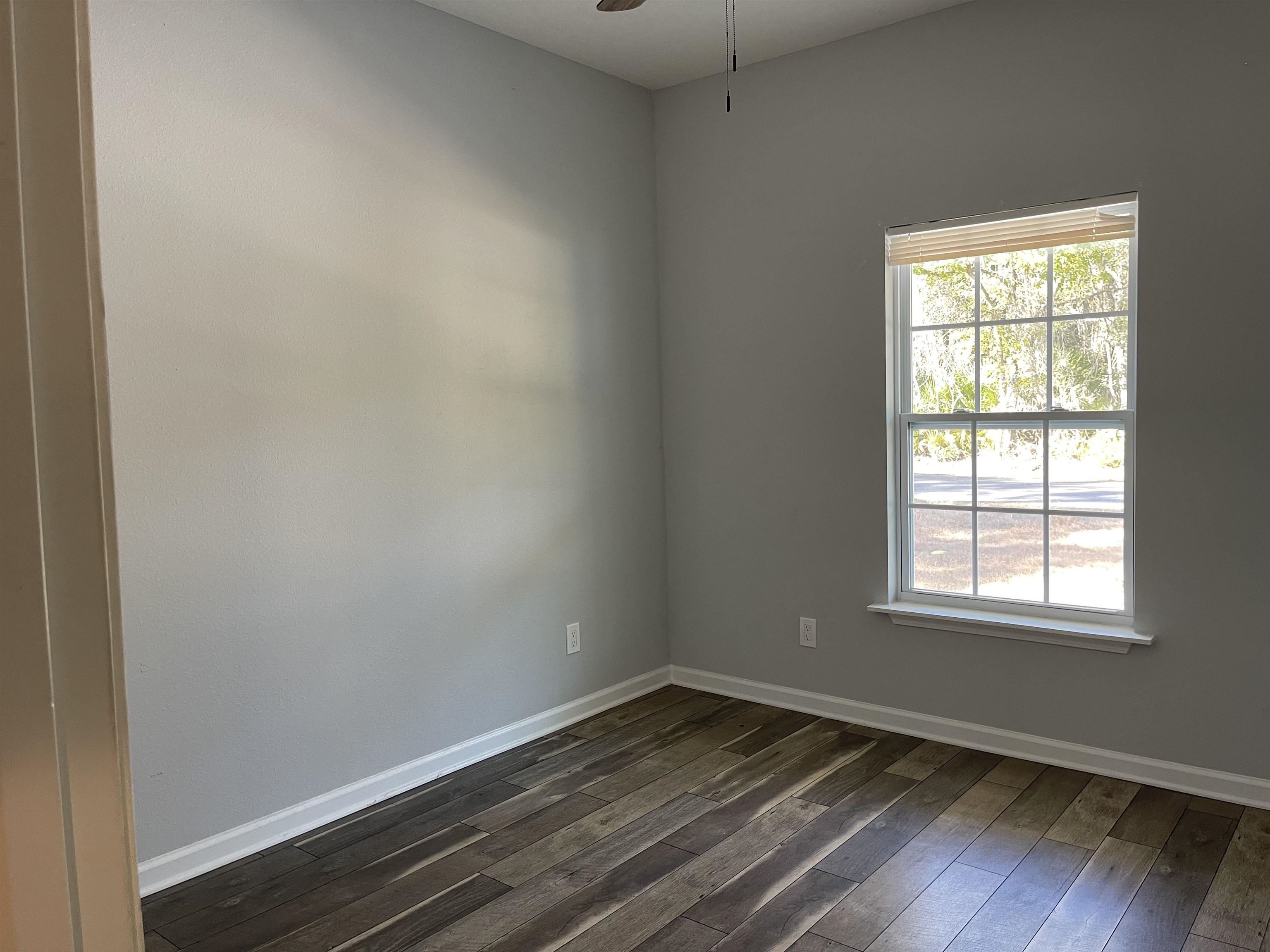 867 Helen Street St. Augustine, FL 32084 - Photo 10 of 11 an empty room with wooden floor and windows