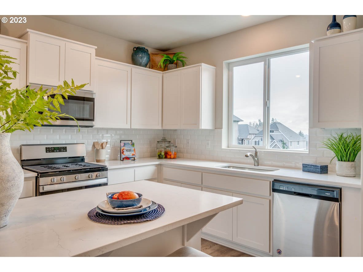 2632 26th Loop Springfield, OR 97477 - Photo 4 of 12 a kitchen with stainless steel appliances a sink a stove and a window