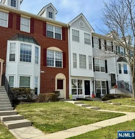 a front view of a residential apartment building with a yard