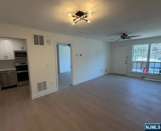 an empty room with windows and cabinet